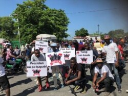 Protesters hold posters that say Lage Pye Ou (step on it), the theme of the protest, Oct 13, 2019. (Photo: M. Vilme/VOA Creole)
