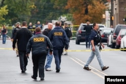 Police officers walk near the site where Ahmad Khan Rahami, sought in connection with a bombing in New York, was taken into custody in Linden, New Jersey, U.S., Sept. 19, 2016.