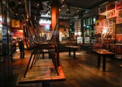 Staff at a restaurant and bar, left, talk after closing shop for the day in Amsterdam, Netherlands, Nov. 29, 2021, after a tougher COVID-19 lockdown went into effect.