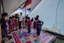 Salah satu materi pembejalaran yang dilakukan para relawan mengajar kampanye Taki Mi'guru adalah pemahaman tentang Covid-19 dengan permainan ular tangga, Senin, 15 Maret 2021. (Foto: Saleh Mandar/Pokja Pendidikan Mamuju)