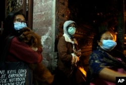 Villagers wear masks as they prepare to evacuate from their homes near the crater of Mount Agung at Besakih village, Karangasem, Bali, Indonesia, Nov. 25, 2017. A volcano on the Indonesian tourist island erupted for the second time in a week on Saturday.