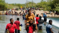 Haitian migrants use a dam to cross into the US from Mexico, Sept. 18, 2021, in Del Rio, Texas.
