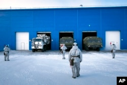 In this photo taken on April 3, 2019, a Russian military's Pansyr-S1 air defense system, left, and two Bastion missile launchers, right, leave a garage during a military drill on Kotelny Island.