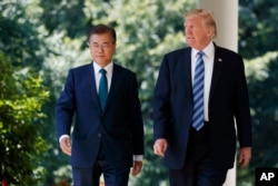 FILE - U.S. President Donald Trump walks with South Korean President Moon Jae-in to make statements in the Rose Garden at the White House in Washington, June 30, 2017.