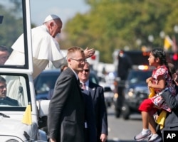 Pope Francis reaches to give a blessing to Sophie Cruz, 5, from suburban Los Angeles, during a parade in Washington, Sept. 23, 2015.