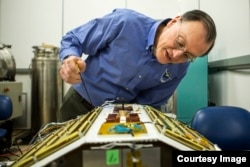 Christopher Ruf, Director of the Space Physics Research Laboratory and Atmospheric, Oceanic and Space Sciences Professor at the University of Michigan, inspects CYGNSS, February 12, 2015.