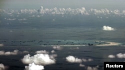 FILE - An aerial photo taken though a glass window of a Philippine military plane shows the alleged ongoing land reclamation by China on mischief reef in the Spratly Islands in the South China Sea, west of Palawan, Philippines.