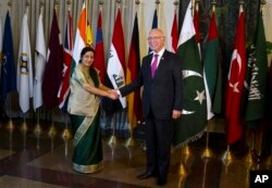 FILE - Indian Foreign Minister Sushma Swaraj (L) shakes hand with Pakistan's top adviser for foreign affairs, Sartaj Aziz, prior to their meeting in Islamabad, Pakistan, Dec. 9, 2015.