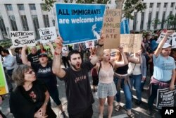 Protesters carry signs and chant slogans in front of Federal Courthouse in Los Angeles, June 26, 2018.