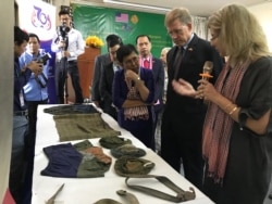 លោក W. Patrick Murphy ឯកអគ្គរដ្ឋទូត​សហរដ្ឋ​អាមេរិក​កម្ពុជា​ និង​អ្នកស្រី​ភឿង សកុណា រដ្ឋមន្ត្រី​ក្រសួង​វប្បធម៌ ស្តាប់​ការពន្យល់​ពី​របៀប​ថែទាំ​សម្លៀក​បំពាក់​ចាស់ៗ​របស់​ជនរងគ្រោះ​មន្ទីរ​ស-២១ ពី​អ្នកជំនាញ។ (ហ៊ុល រស្មី/VOA)