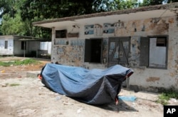 A Lady Justice statue lies covered with a plastic sheet inside the Supreme Court premise in Dhaka, Bangladesh, May 26, 2017. The statue was put back in place Saturday near where it was taken down Friday.