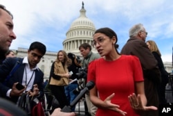 FILE - Rep.-elect Alexandria Ocasio-Cortez, D-N.Y., talks with reporters following a photo opportunity with the freshman class on Capitol Hill in Washington, Nov. 14, 2018.