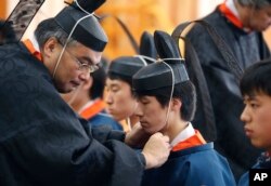 지난 1월 코쿠카쿠인 대학에서 성인의 날은 맞아 교수들이 20살이 된 학생들에게 의식용 모자를 씌우고 있다.