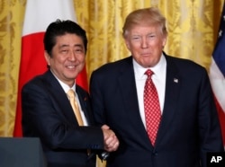 FILE - President Donald Trump, right, and Japanese Prime Minister Shinzo Abe shake hands following their joint news conference in the East Room of the White House in Washington, Feb. 10, 2017.