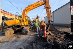Workers fix a sewer main below the sidewalk in Mid City New Orleans, Jan. 31, 2018. New Orleans’ mayor says President Donald Trump’s infrastructure proposal puts the onus on cities and states to raise taxes and fees to pay for the improvements.