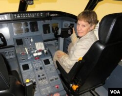 Central Washington University Professor Teresa Sloan sits in the aviation program's CRJ-200 turbojet flight simulator. (T. Banse/VOA)