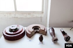 FILE - A portable display teaches children and farmers what landmines and hand grenades look like. (U. Filimonova/VOA)