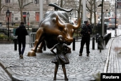 Patung "Fearless Girl" menantang Banteng Wall Street di New York (7/3).