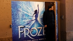 FILE PHOTO: A worker looks out from the closed St James theater where the musical "Frozen" plays after it was announced that Broadway shows will cancel performances due to the coronavirus outbreak in New York, U.S., March 12, 2020.