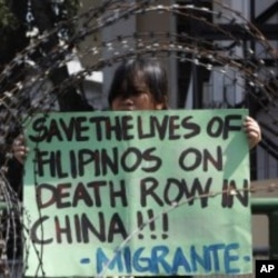 A member of Migrante International, a Filipino migrant organisation, displays a placard demanding legal assistance for her relatives during a protest outside the presidential palace in Manila, February 21, 2011.