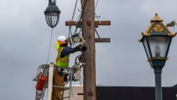 AT&T workers wear face masks during the coronavirus pandemic as they deploy fiber optic lines for a cell phone tower station in the Chinatown neighborhood of Los Angeles, Friday, June 5, 2020. (AP Photo/Damian Dovarganes)