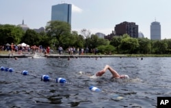 Orang-orang berenang di Sungai Charles selama acara “City Splash,” hari Selasa, 18 Juli 2017 di Boston