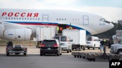 Vehicles pull up to a Russian aircraft to load freight at Dulles International Airport Dec. 31, 2016, in Sterling, Virginia, just outside Washington, D.C. The special flight arrived to pick up Russian diplomats expelled by President Barack Obama as part of sanctions he imposed on Russia for what the U.S. intelligence community agrees was state-sponsored Russian cyber meddling in the U.S. presidential election.