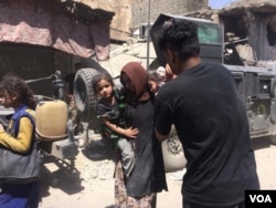 Soldiers help families as they arrive, but tensions are high after so many suicide bombings. Mosul, Iraq, July 5, 2017. (H. Murdock/VOA)