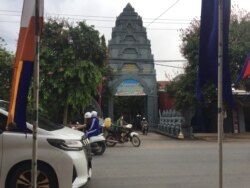 ពលរដ្ឋធ្វើដំណើរ​ឆ្លងកាត់​មុខវត្ត​ចំពុះក្អែក​ក្នុងរាជធានីភ្នំពេញ​ដែល​ត្រូវ​បាន​រកឃើញ​ថា​មាន​វិជ្ជមាន​កូវីដ១៩​នៅ​ក្នុងវត្ត នៅថ្ងៃទី២៤ ខែកញ្ញា ឆ្នាំ២០២១។ (លាស់ លីបលីប/VOA)