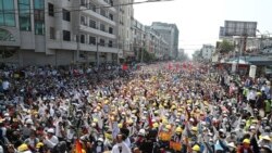 Anti-coup protesters raise their hands with clenched fists during a rally near the Mandalay Railway Station in Mandalay, Myanmar, Monday, Feb. 22, 2021.