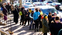 People wait in line to receive free COVID-19 rapid test kits, in Philadelphia, Pennsylvania, Dec. 20, 2021. Omicron has raced ahead of other variants and is now the dominant version of the coronavirus in the United States.