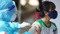 A youth receives the Pfizer-BioNTech Covid-19 coronavirus vaccine at Cu Chi Town Primary School in Ho Chi Minh City on Oct. 27, 2021, as Vietnam began vaccinating adolescents between the ages of 12 to 17.