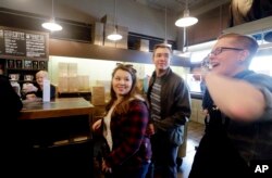 Starbucks assistant manager Lindsey Pringle, right, directs the final customers of the day at the Pike Place Market Starbucks, commonly referred to as the original Starbucks, May 29, 2018, in Seattle.