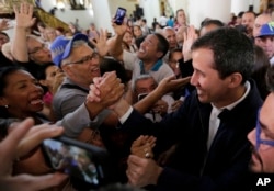 Opposition National Assembly leader Juan Guaido, right, who declared himself interim president, greets supporters as he leaves church after attending Mass in Caracas, Venezuela, Jan. 27, 2019.