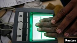 A villager goes through the process of a fingerprint scanner for the Unique Identification (UID) database system at an enrollment center at Merta district in the desert Indian state of Rajasthan, Feb. 22, 2013.