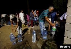 People line up to collect water from a spring in the Newlands suburb as fears over the city's water crisis grow in Cape Town, South Africa, Jan. 25, 2018.