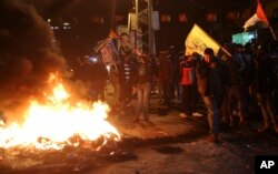 Palestinian protesters burn tires as they wave Palestinian flags and pictures of late Palestinian president Yasser Arafat during a protest in Gaza City, Dec. 6, 2017. Defying worldwide warnings, U.S. President Donald Trump on Wednesday broke with decades of U.S. policy on Jerusalem.