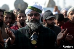 FILE - Supporters of the Tehreek-e-Labbaik Pakistan Islamist political party say a prayer after their leader. Khadim Hussain Rizvi, announced an end to their protest at Faizabad junction in Islamabad, Pakistan, Nov. 27, 2017.