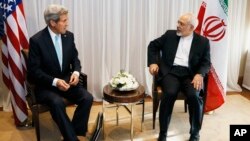 U.S. Secretary of State John Kerry, left, waits with Iranian Foreign Minister Mohammad Javad Zarif before a meeting in Geneva, Switzerland, Jan. 14, 2015.