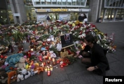 A woman lays flowers at a makeshift memorial for victims of a Russian airliner which crashed in Egypt, outside Pulkovo Airport in St. Petersburg, Russia, Nov. 4, 2015.