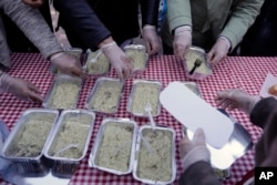 Volunteers of the soup kitchen ''O Allos Anthropos'' (The other Man) deliver free food for all at Monastiraki square in central Athens, April 25, 2017.