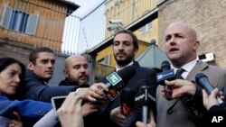 FILE - Italian journalists Gianluigi Nuzzi (R) and Emiliano Fittipaldi, authors of two books on financial wrongdoings at the Vatican, talk to reporters outside Vatican City's Perugino gate, Nov. 24, 2015.