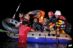 A migrant child sits aboard a dinghy with others as they try to start their journey from the coastal town of Bodrum, Turkey, to the nearby Greek island of Kos, Aug. 18, 2015.