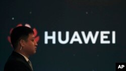 지난 9일 중국 베이징에서 화웨이 새 제품 출시기념행사가 열린 가운데 보안요원이 화웨이 로고 앞에서 보초를 서고 있다.