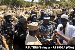 Mkuu wa Polisi Muhammad Musa Katsina (wapili kulia) akikabidhi ng'ombe waliokuwa wameibiwa kwa Zubairu Hamza, mwakilishi wa wilaya za Sumaila na Takai eneo la jimbo la Kano, Nigeria October 23, 2015. REUTERS/Stringer - RTX1SYRX