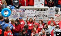 Teachers from across Kentucky hold up signs as they fill the state Capitol to rally for increased funding and to protest last-minute changes to their state-funded pension system, in Frankfort, Kentucky, April 2, 2018.