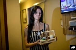 In this June 9, 2017 photo, Municipal Theatre of Rio de Janeiro ballet dancer Renata Gouveia shows truffles she sells to make ends meet in Rio de Janeiro, Brazil. Thousands of public workers are not being paid on time, or at all. Among them is the ballet