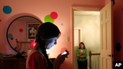 Ana ŠIferl šalje SMS poruku svojoj mami Džoani u Le Grejndžu u Ilionoisu. (Foto: AP/Charles Rex Arbogast)