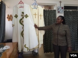 Sarah Ndungu, secretary and accountant for the Dolly Craft Sewing Project in Kangemi slum, Nairobi, shows the two chasubles her group designed and constructed for Pope Francis during his visit to Kenya later this month, Nov. 12, 2015. (Photo: J. Craig / VOA)