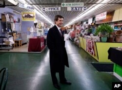 FILE - Mayor Pete Buttigieg walks around as he talks with people at Farmers Market in South Bend, Ind., Jan. 10, 2019. At 37, Pete Buttigieg is just a few years older than the minimum age required to serve as president of the United States.